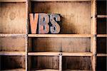 The word VBS written in vintage wooden letterpress type in a wooden type drawer.