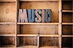 The word MUSIC written in vintage wooden letterpress type in a wooden type drawer.