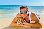 jack russell dog with owner lying at the beach on summer vacation holidays, together and very close
