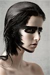 amazing close-up beauty portrait of cute girl with strong black painted make-up on her visage skin and on hair