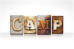 The word "CAMP" written in rusty metal letterpress type isolated on a white background.