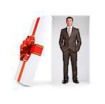 Serious businessman looking at camera in gift box with ribbon on isolated white background