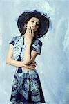 summer fashion shoot of cute female in romantic pose with hat and elegant skirt and top, long hair natural make-up