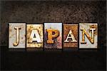 The word "JAPAN" written in rusty metal letterpress type on a dark textured grunge background.