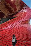 Woman is admiring the Vanke Pavilion (China's largest residetnial real estate organization) designed by Daniel Libeskind at Milan Expo 2015, Italy