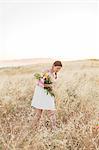 Woman with flowers walking in meadow