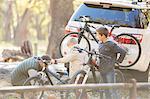 Father and sons unloading bicycles from car