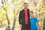 Portrait smiling father and son hugging outdoors