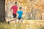 Father and son jogging in autumn park
