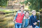 Portrait smiling father and sons with fishing rods