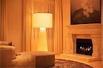 Illuminated floor lamp next to marble fireplace