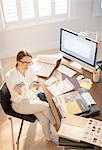 Interior designer examining swatches at desk in home office