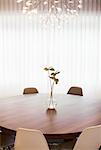 Modern chandelier over anthurium bouquet on round dining table