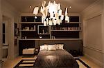 Illuminated modern paper chandelier hanging in bedroom