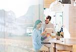 Couple using digital tablet in kitchen