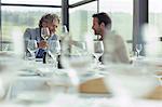 Men toasting wine glasses at restaurant table