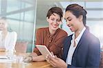 Smiling businesswomen using digital tablet in office