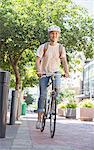 Young woman with helmet riding bicycle in urban park