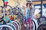 Portrait smiling women hugging with bicycle in bicycle shop