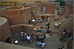 Traditional lifestyle of families on courtyards outside of homes, with modern little bike, Tiebele, Burkina Faso