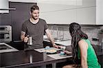 Young man pouring breakfast coffee for girlfriend