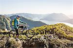 Young woman on mountain bike, looking at view, Lake Como, Italy