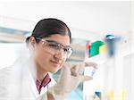 Female scientist viewing sample in eppendorf ahead of DNA testing in a laboratory.