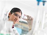 Female scientist viewing sample in eppendorf ahead of DNA testing in a laboratory.