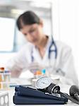 Female doctor examining test tube at desk in clinic