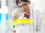 Female scientist looking at chemical sample in lab