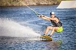 Mid adult man swerving on wakeboard in sea, Cagliari, Sardinia, Italy