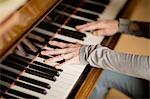 Hands of mature woman playing piano