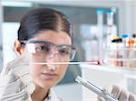 Female scientist extracting DNA sample swab for genetic tests in laboratory