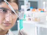 Female scientist pippetting sample into eppendorf tube for analysis in laboratory