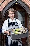 Portrait of chef holding box of asparagus