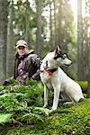 Woman with hunting dog in forest