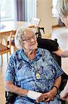 Nurse in care home talking with senior woman