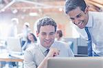 Businessmen working at laptop in office