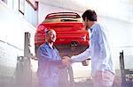 Mechanic and customer handshaking in auto repair shop