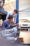 Mechanic with clipboard talking to customer in auto repair shop