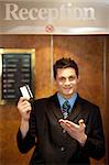 Snap shot of handsome guy holding cash card and showing it to camera