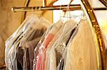 Fashionable apparel neatly wrapped and covered. Handing on a rack