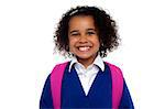 Happy school going girl. Beautiful African student in uniform with backpack smiling at you.