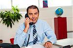 Smart looking smiling male executive on a call.