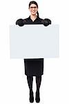 Cheerful female boxer posing from behind a blank whiteboard