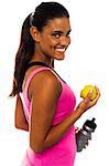 Athletic woman holding sipper bottle and fresh green apple