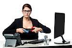 Young professional female cutting her credit card with scissors