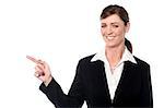 Beautiful corporate woman pointing towards copy space area