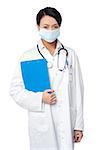 Young female physician wearing surgical mask and holding clipboard