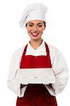 Attractive young female chef delivering pizza to the customer.